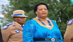 MEC Violet Mathye standing beside an officer in an Arrive Alive poster