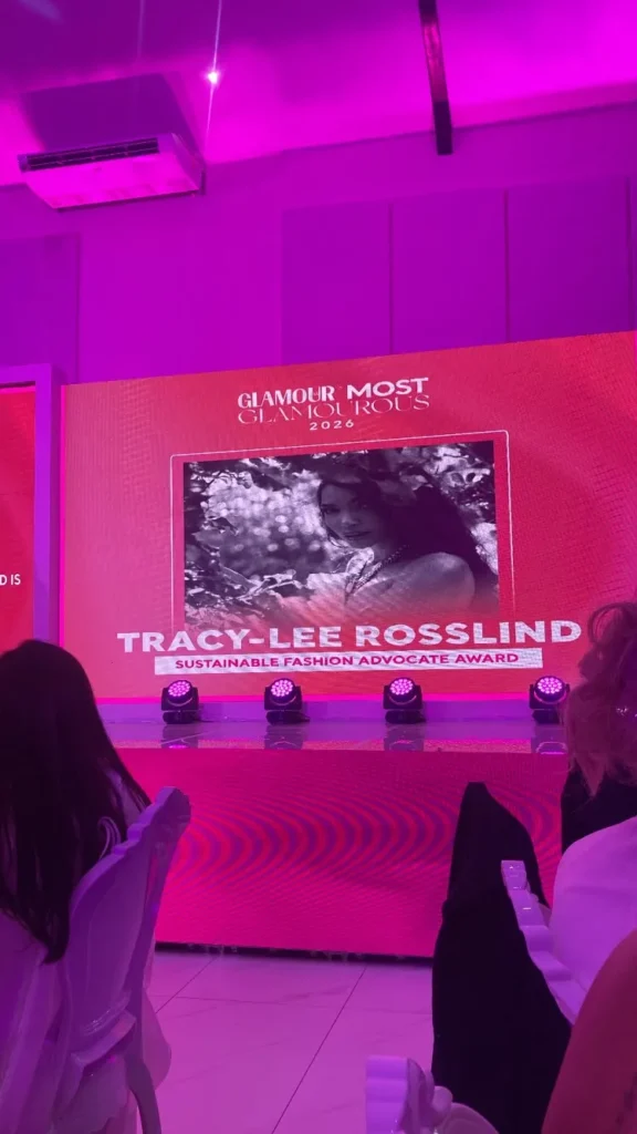 glamour feeder image of the winner of an award being mentioned on an onstage pink billboard