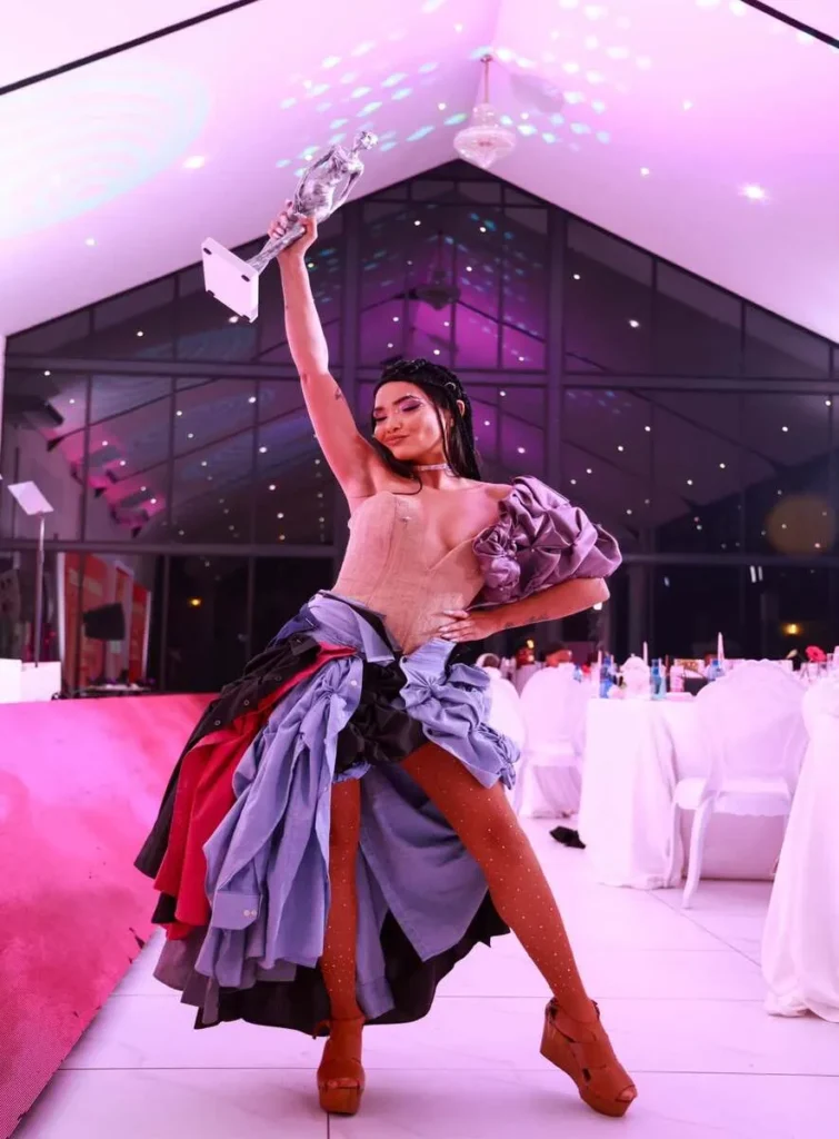 glamour feeder image of a young award winner wearing a pink cocktail gown for an award's evening.