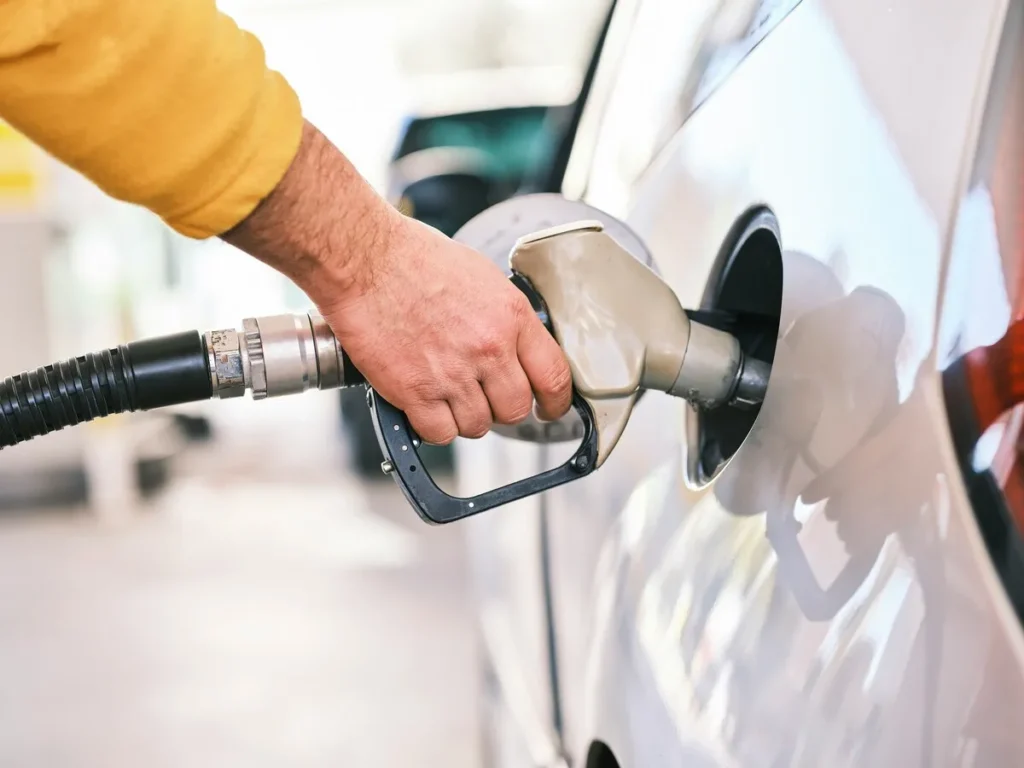 CCSA fuel pump attendant filling gas in a car at a petrol station
